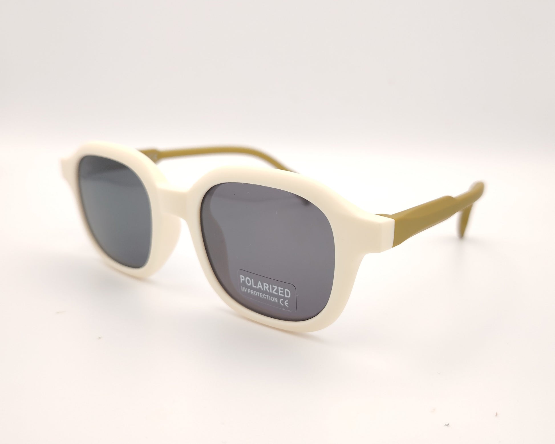 gafas de sol infantiles polarizadas con montura beige y varillas color mostaza con lentes grises.