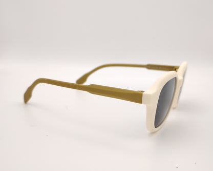 gafas de sol infantiles polarizadas con montura beige y varillas color mostaza con lentes grises.