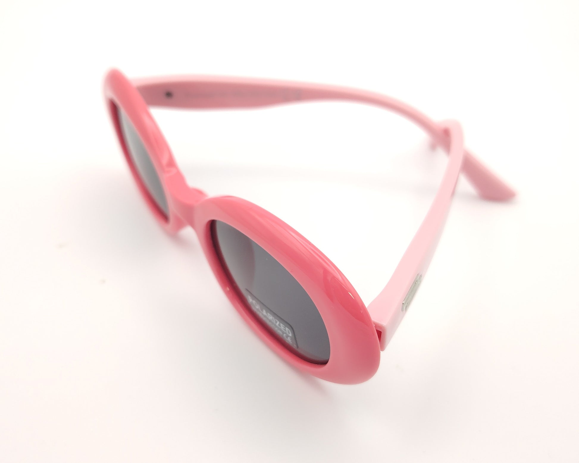 gafas de sol infantiles polarizadas con montura ovalada rosa y varillas en rosa claro y lentes grises con protección uv.