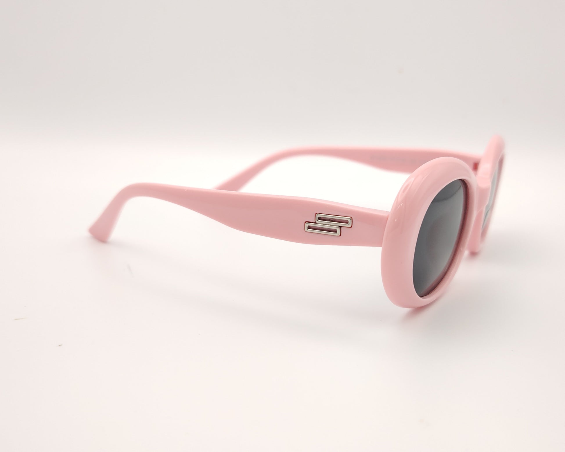 gafas de sol infantiles polarizadas con montura ovalada rosa pastel y lentes grises con protección uv.