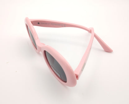 gafas de sol infantiles polarizadas con montura ovalada rosa pastel y lentes grises con protección uv.