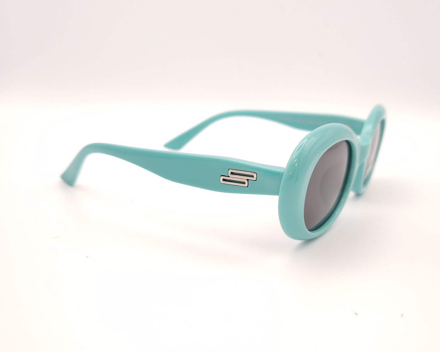 gafas de sol infantiles polarizadas con montura ovalada turquesa y lentes grises con protección uv.