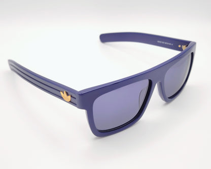 gafas de sol adidas or0127 90v, montura en color azul con logo dorado en las varillas, diseño rectangular deportivo, lentes oscuras para protección solar, estilo urbano y moderno