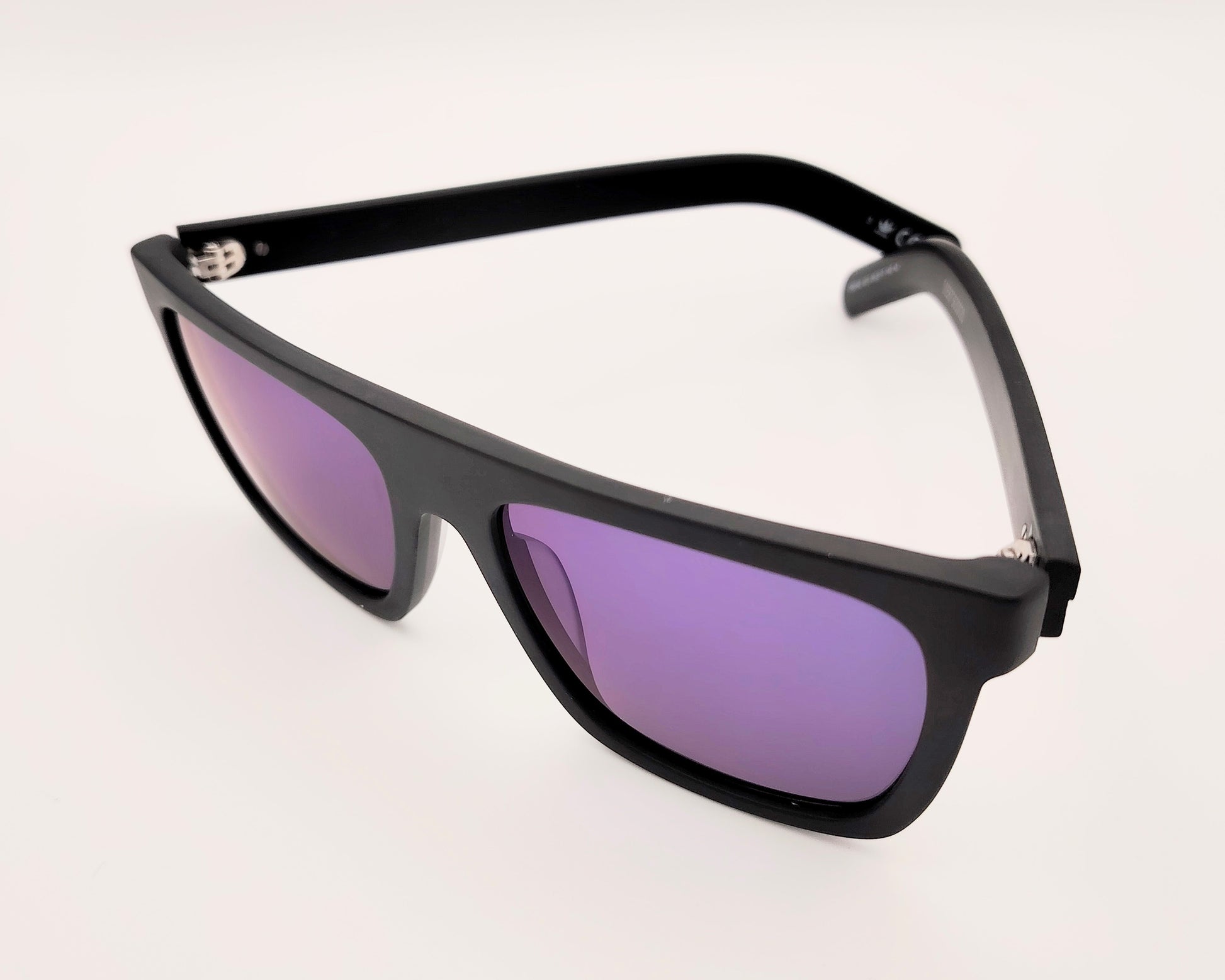 gafas de sol rectangulares con montura negra mate y lentes espejo azul con detalle de logo en las varillas