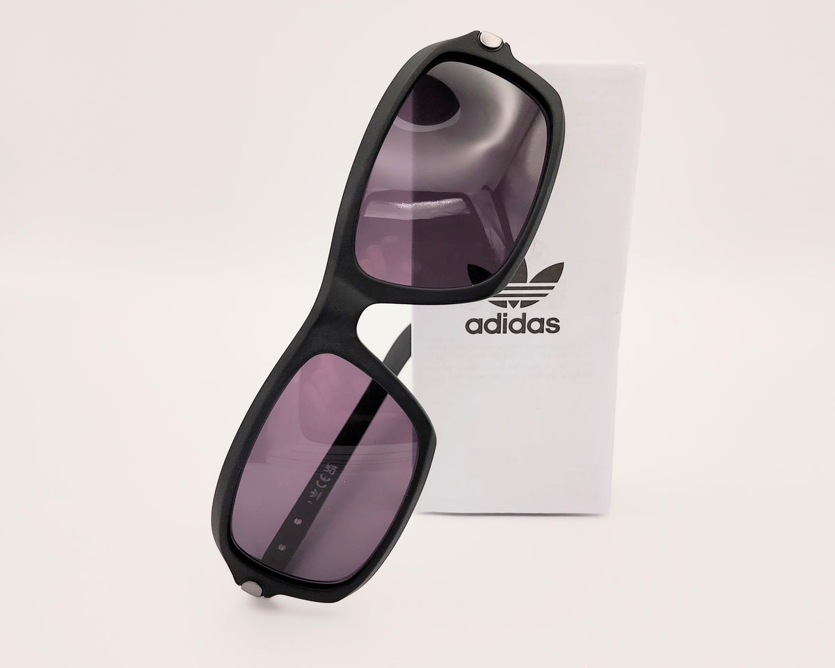 gafas de sol adidas en color negro mate con lentes negras y diseño rectangular ligeramente envolvente