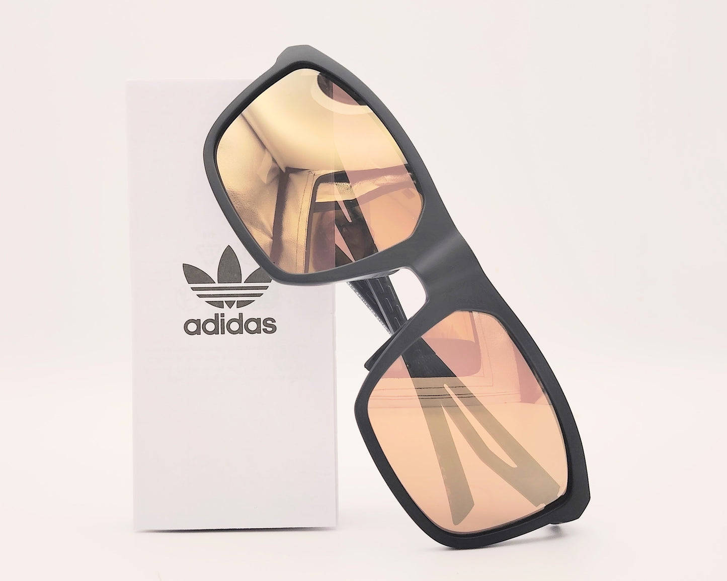 gafas de sol adidas sp0111 de color negro mate con lentes de espejo en dorado con detalles de ventilación en la montura