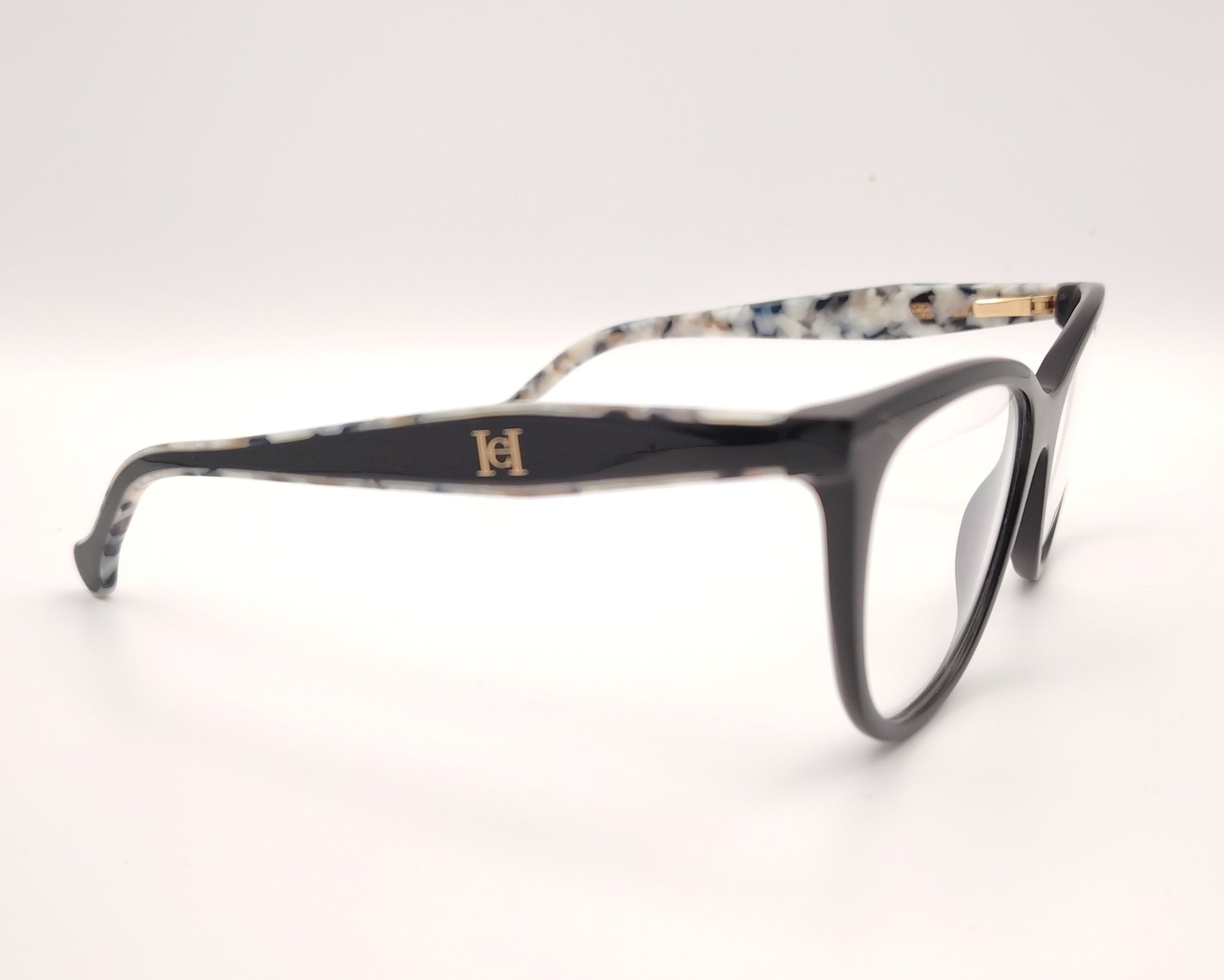 gafas carolina herrera negras con varillas moteadas y clip-on solar con lentes oscuras