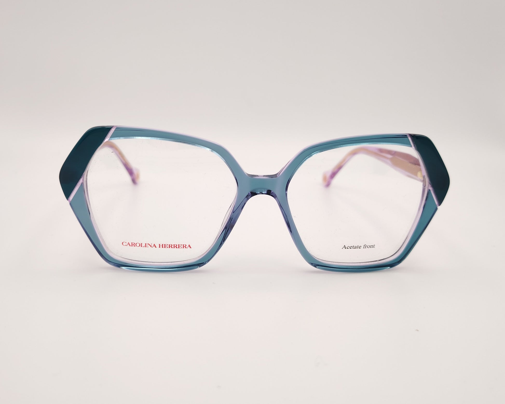 gafas graduadas con montura geométrica en tonos morado y verde agua, varillas rosadas y logo dorado de carolina herrera