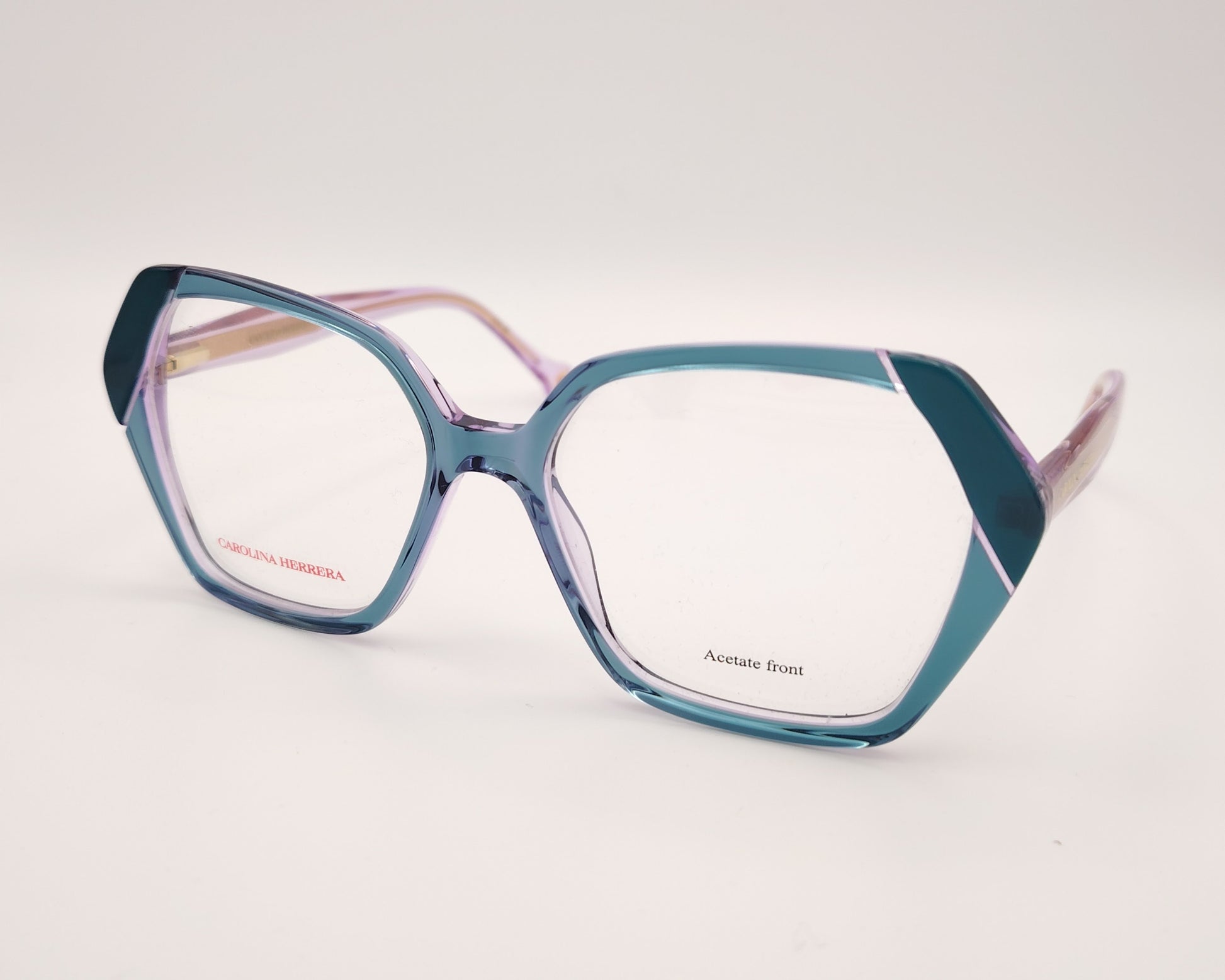gafas graduadas con montura geométrica en tonos morado y verde agua, varillas rosadas y logo dorado de carolina herrera
