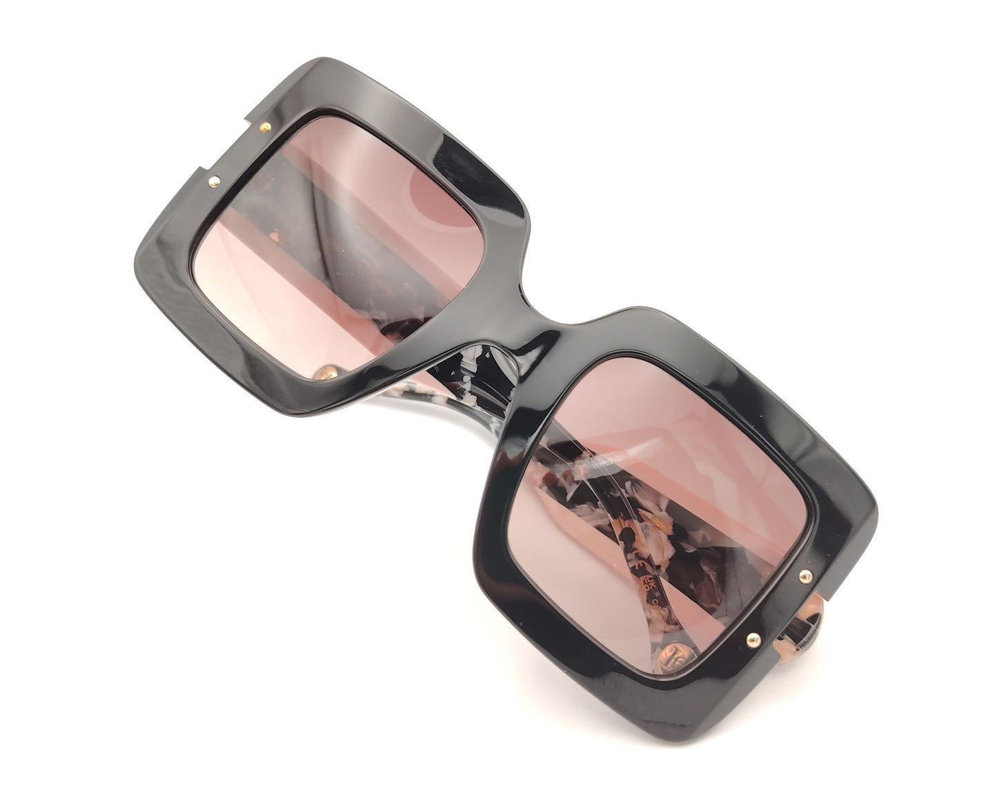 gafas de sol carolina herrera oversize negras con lentes rosadas degradadas y varillas marmoleadas