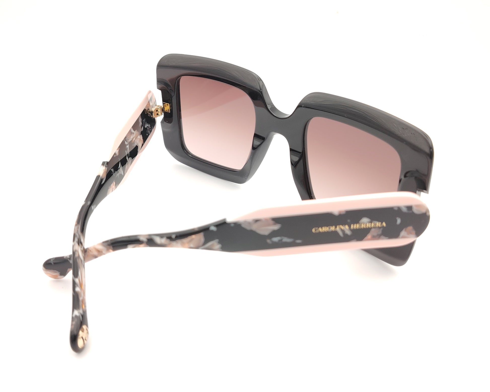 gafas de sol carolina herrera oversize negras con lentes rosadas degradadas y varillas marmoleadas