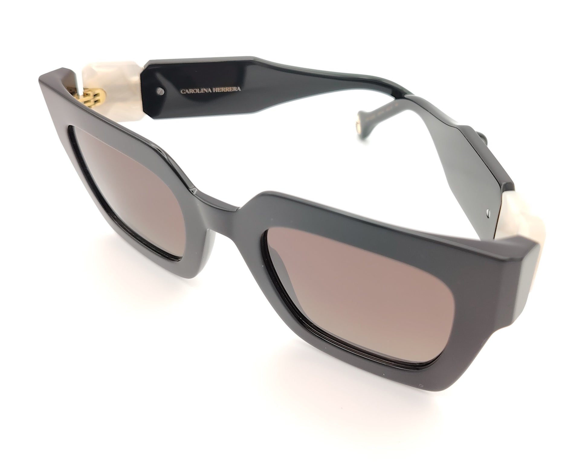 gafas de sol carolina herrera negras con varillas anchas con detalle en blanco nacarado y cristales marrones