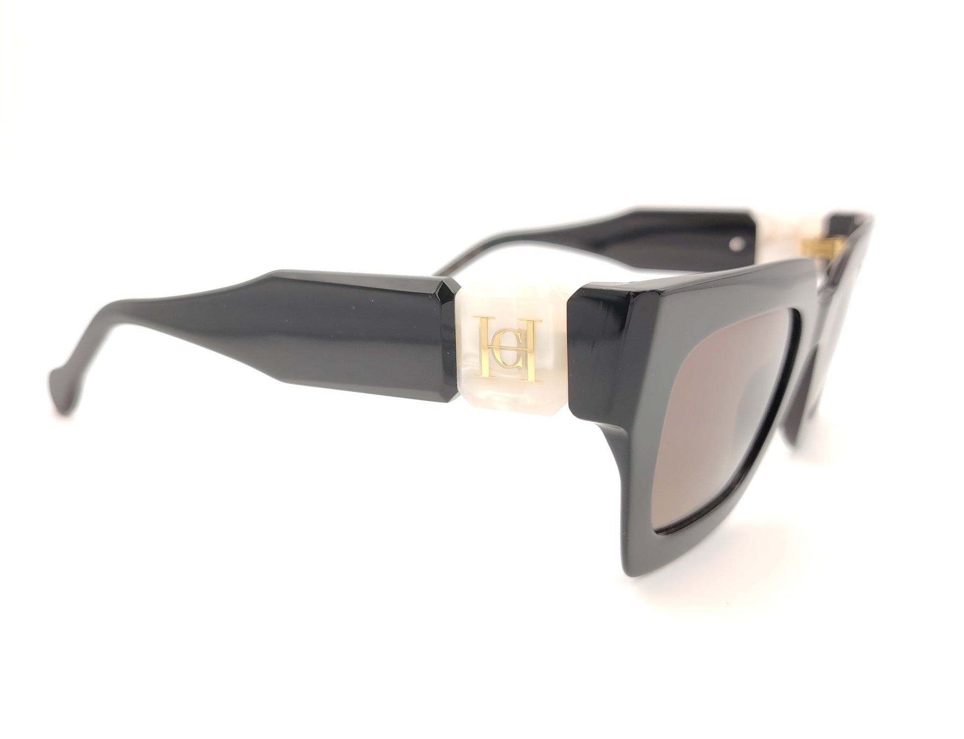 gafas de sol carolina herrera negras con varillas anchas con detalle en blanco nacarado y cristales marrones