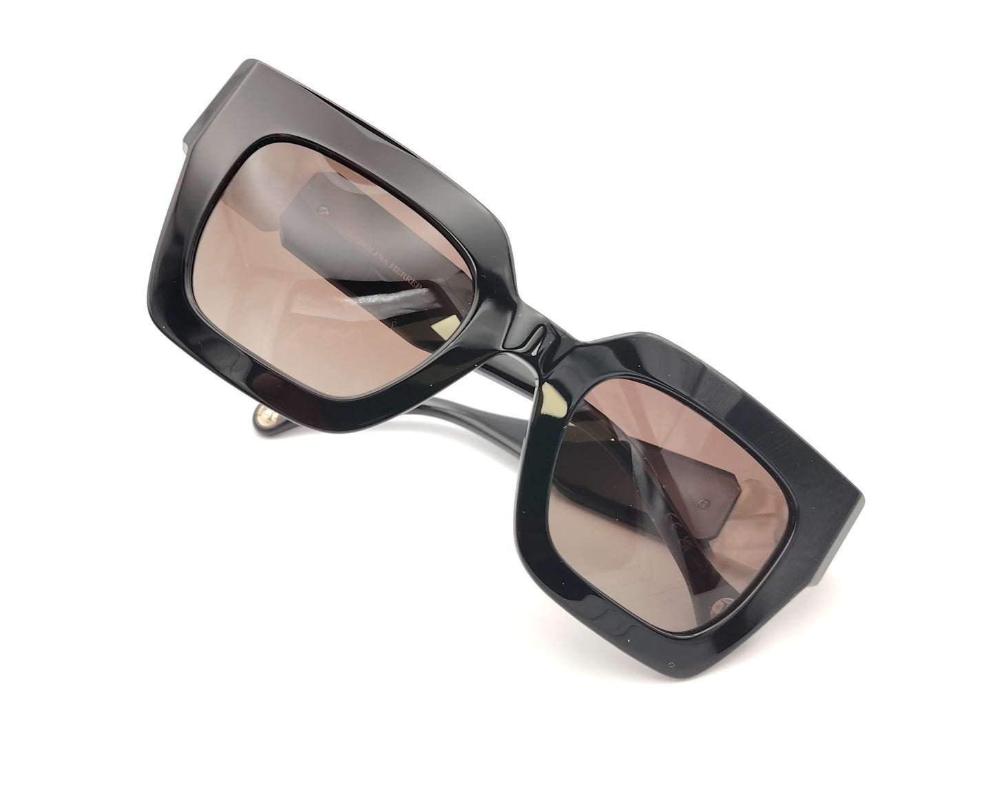 gafas de sol carolina herrera negras con varillas anchas con detalle en blanco nacarado y cristales marrones