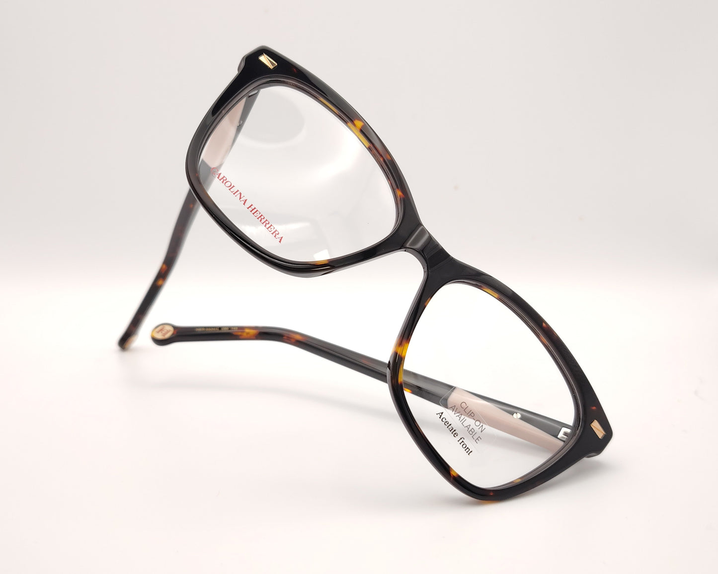 gafas graduadas carolina herrera de forma cat eye en carey oscuro con varillas negro y rosa claro y clip on solar