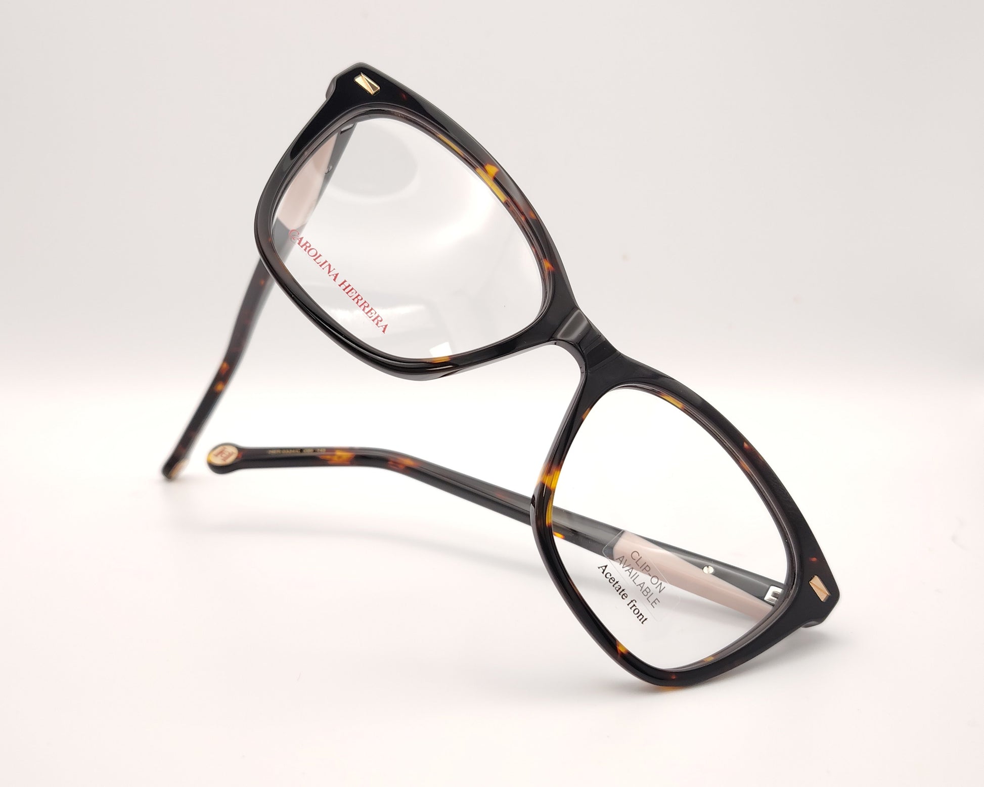 gafas graduadas carolina herrera de forma cat eye en carey oscuro con varillas negro y rosa claro y clip on solar