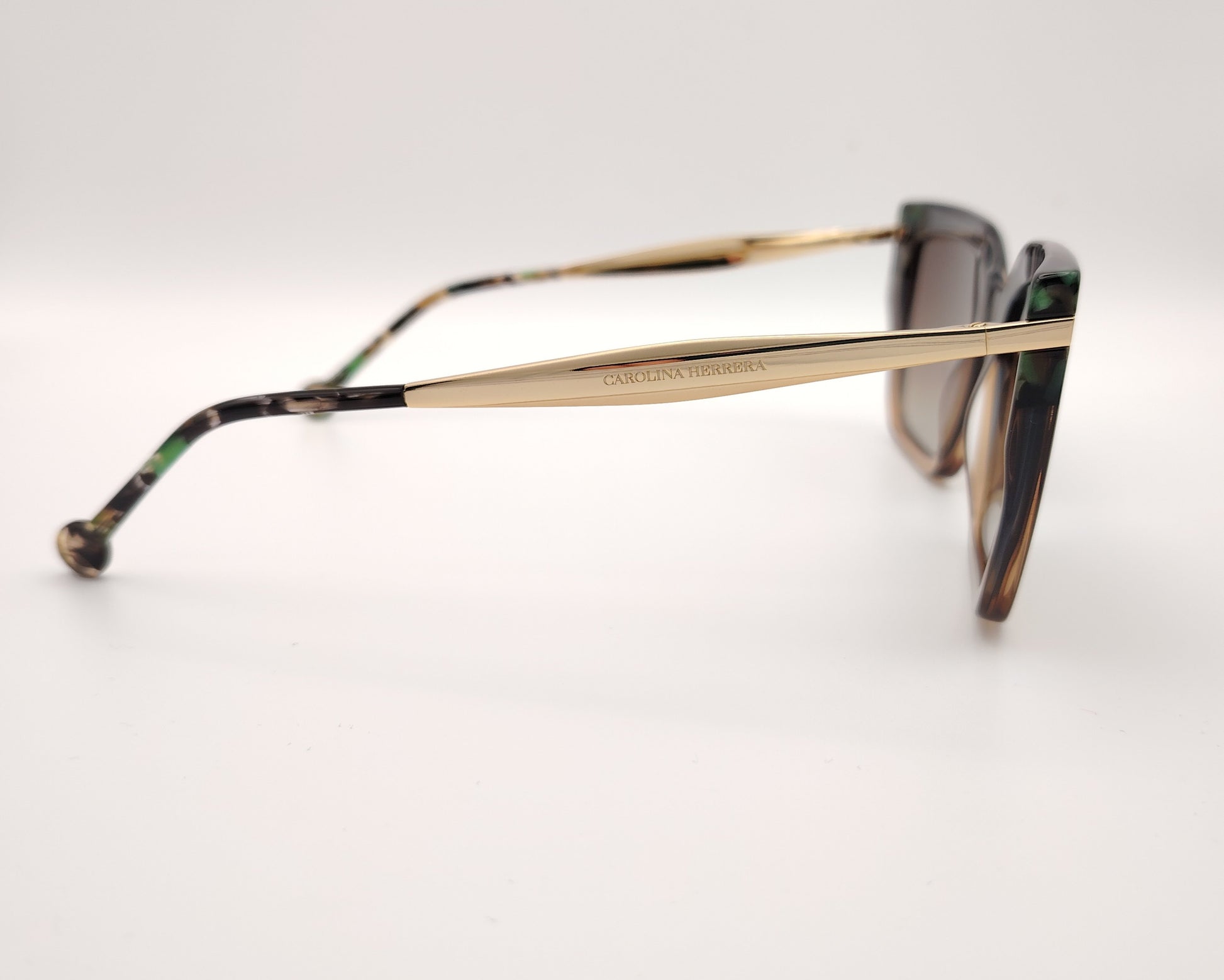 gafas de sol carolina herrera de acetato  forma cuadrada en verde y marrón con detalle carey y varillas doradas