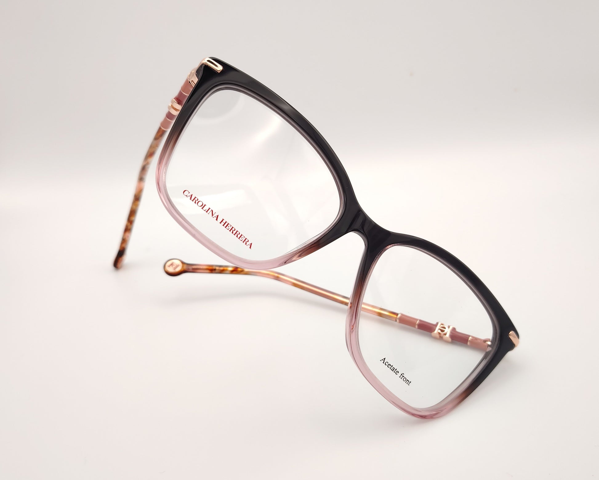 gafas carolina herrera  con degradado de berenjena a rosa y varillas finas doradas con detalles carey 