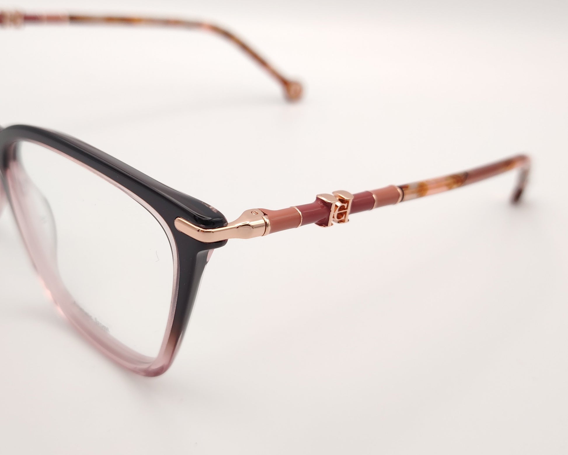 gafas carolina herrera  con degradado de berenjena a rosa y varillas finas doradas con detalles carey 
