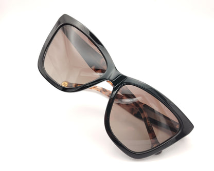 gafas de sol carolina herrera cat eyes negras oversize con varillas carey y lentes degradadas marrones