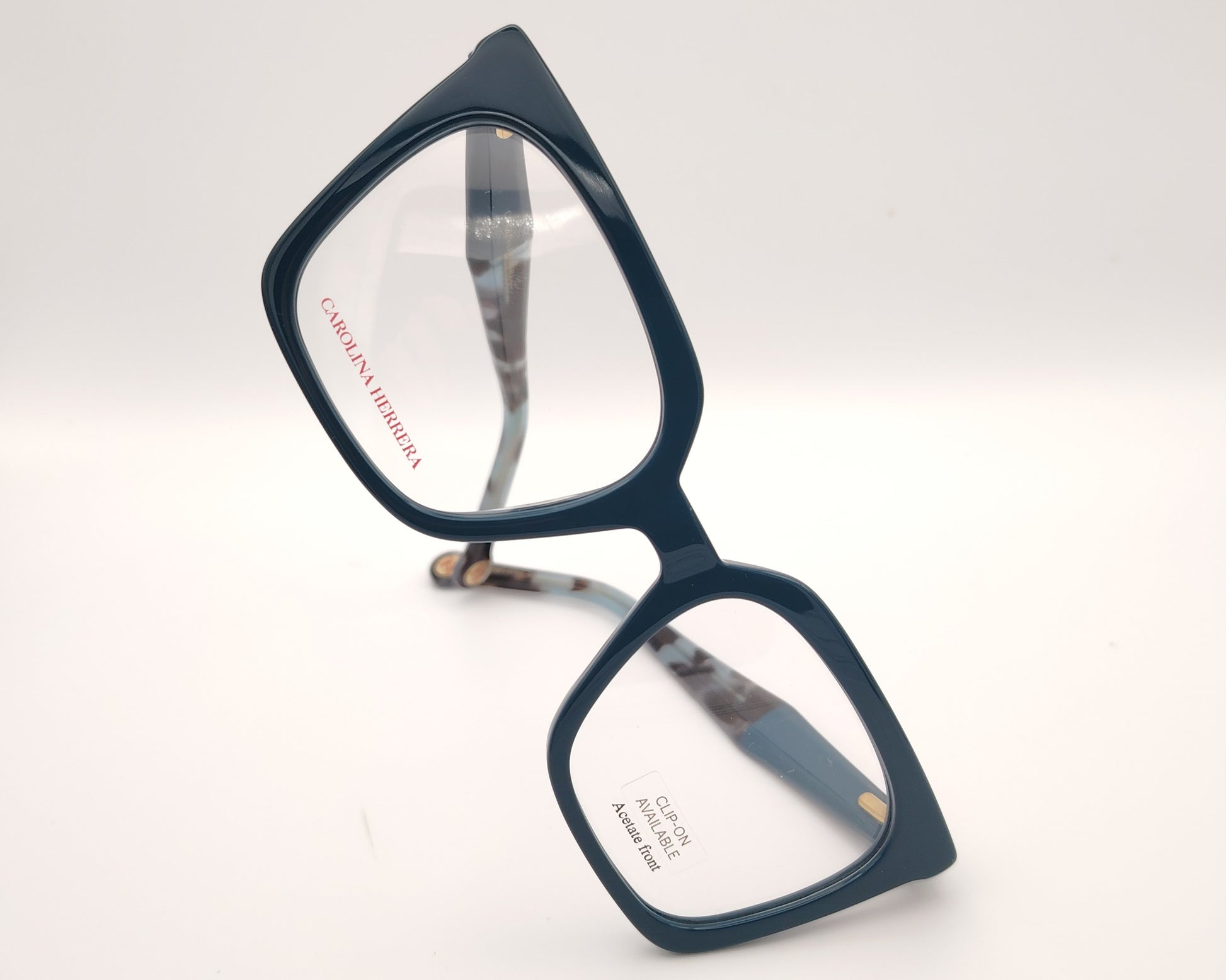 gafas carolina herrera azul petróleo con clip solar negro y forma geométrica