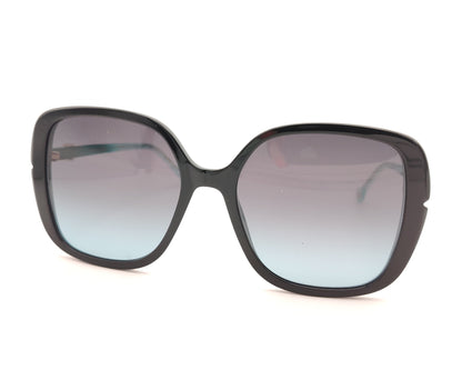 gafas de sol carolina herrera oversize negras con lentes degradadas y varillas turquesa