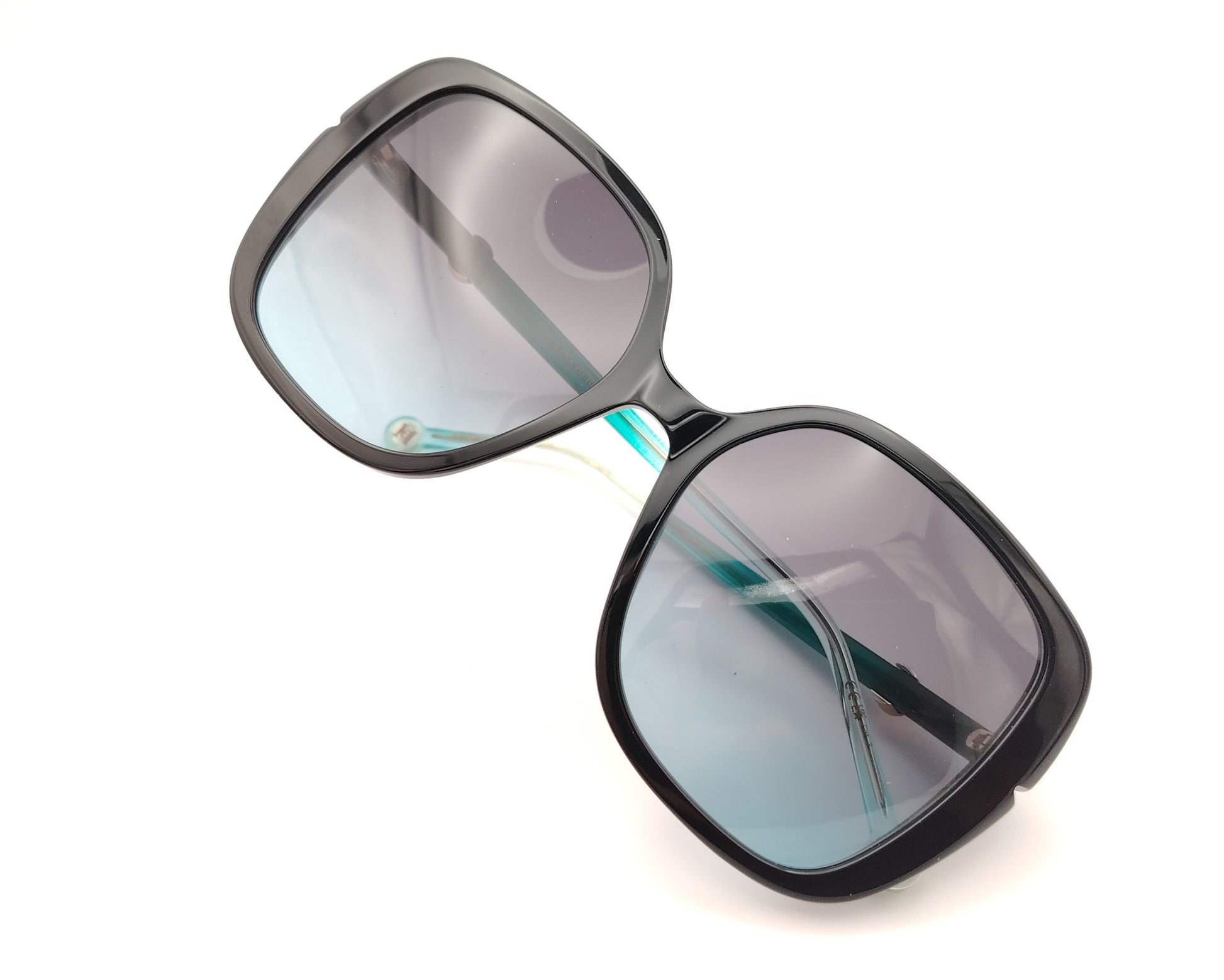 gafas de sol carolina herrera oversize negras con lentes degradadas y varillas turquesa