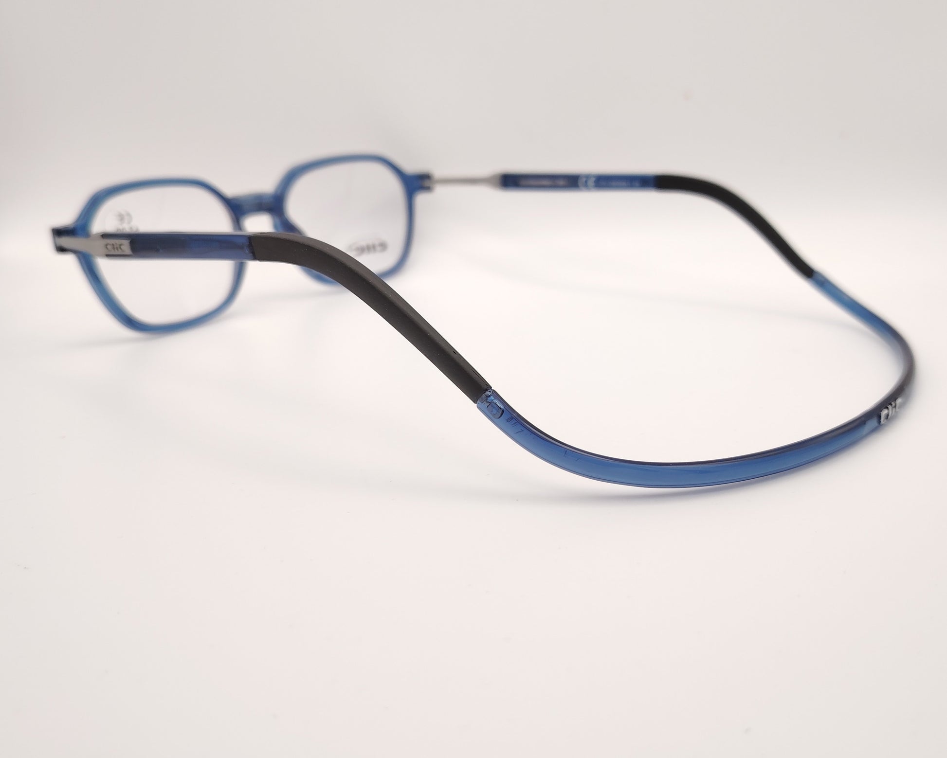 detalle de montura azul geométrica clic flex con varillas metálicas y cierre frontal magnético