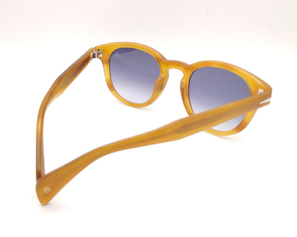 gafas de sol con montura translúcida color miel y lentes degradadas azules de forma redondeada