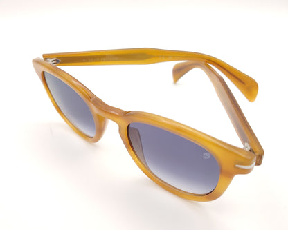 gafas de sol con montura translúcida color miel y lentes degradadas azules de forma redondeada