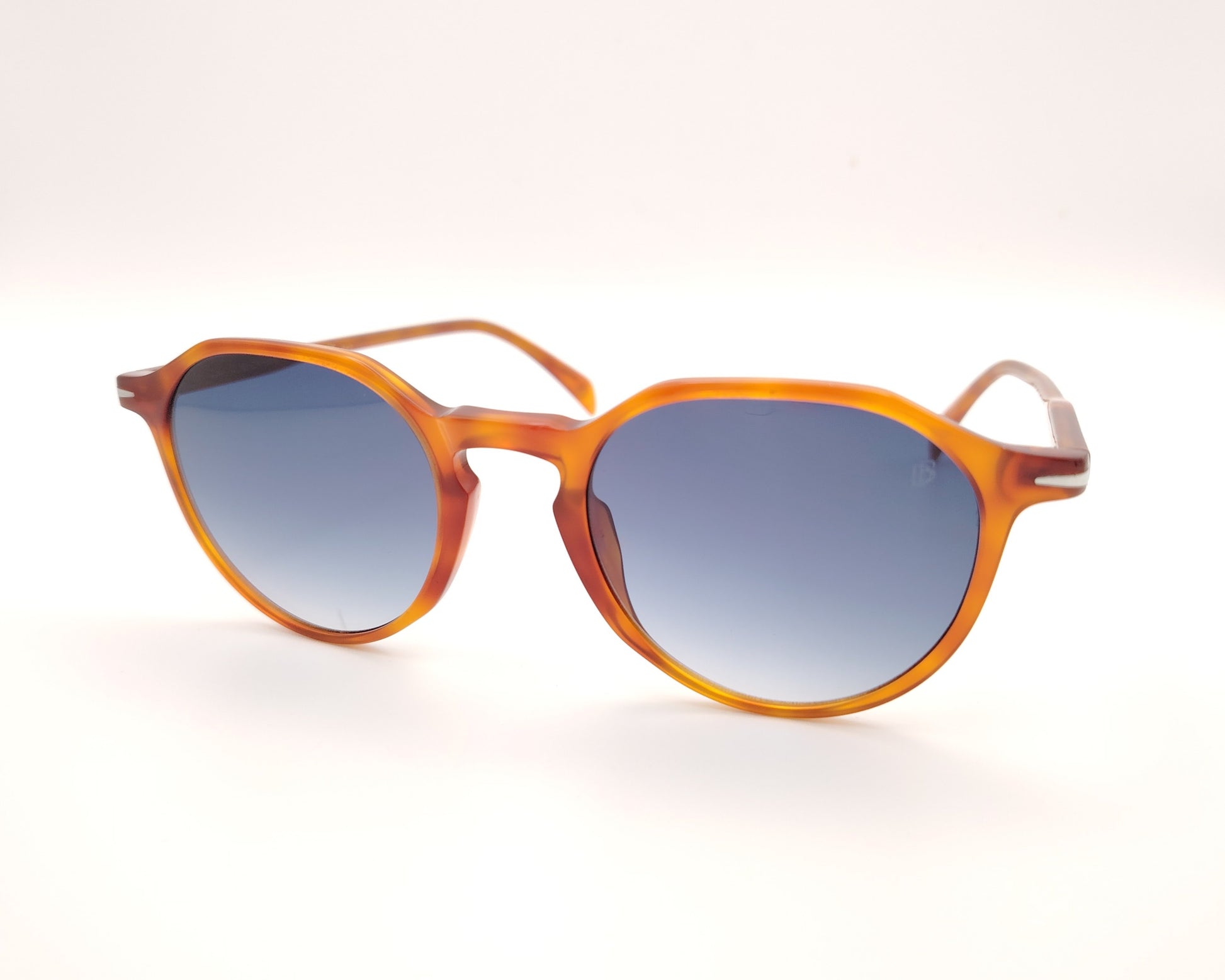 gafas de sol con montura translúcida color ámbar y lentes degradadas azules de forma redondeada