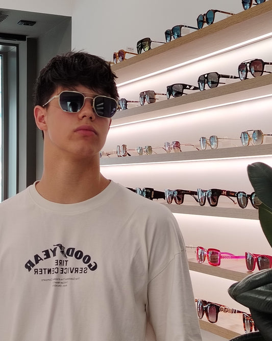 gafas de sol metálicas doradas con lentes azules y montura geométrica