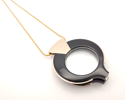 lente de lectura plegable flippan look en negro con borde dorado y cadena fina dorada