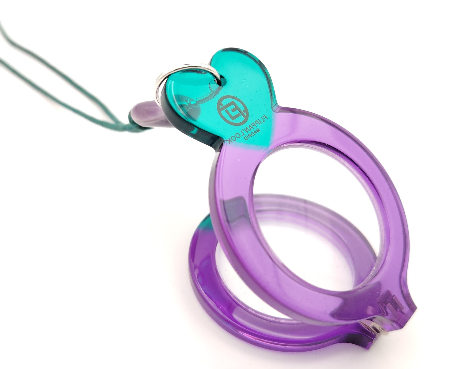 lente de lectura plegable violeta con forma redonda y detalles en turquesa colgado de un cordón