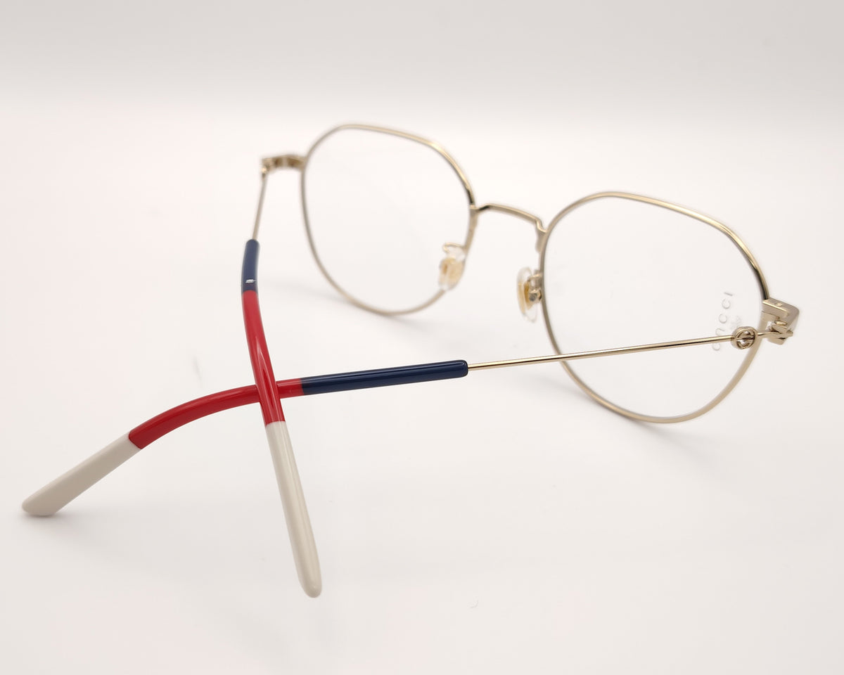 gafas gucci metálicas doradas con forma redonda y varillas en rojo azul y beige