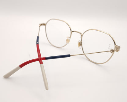 gafas gucci metálicas doradas con forma redonda y varillas en rojo azul y beige
