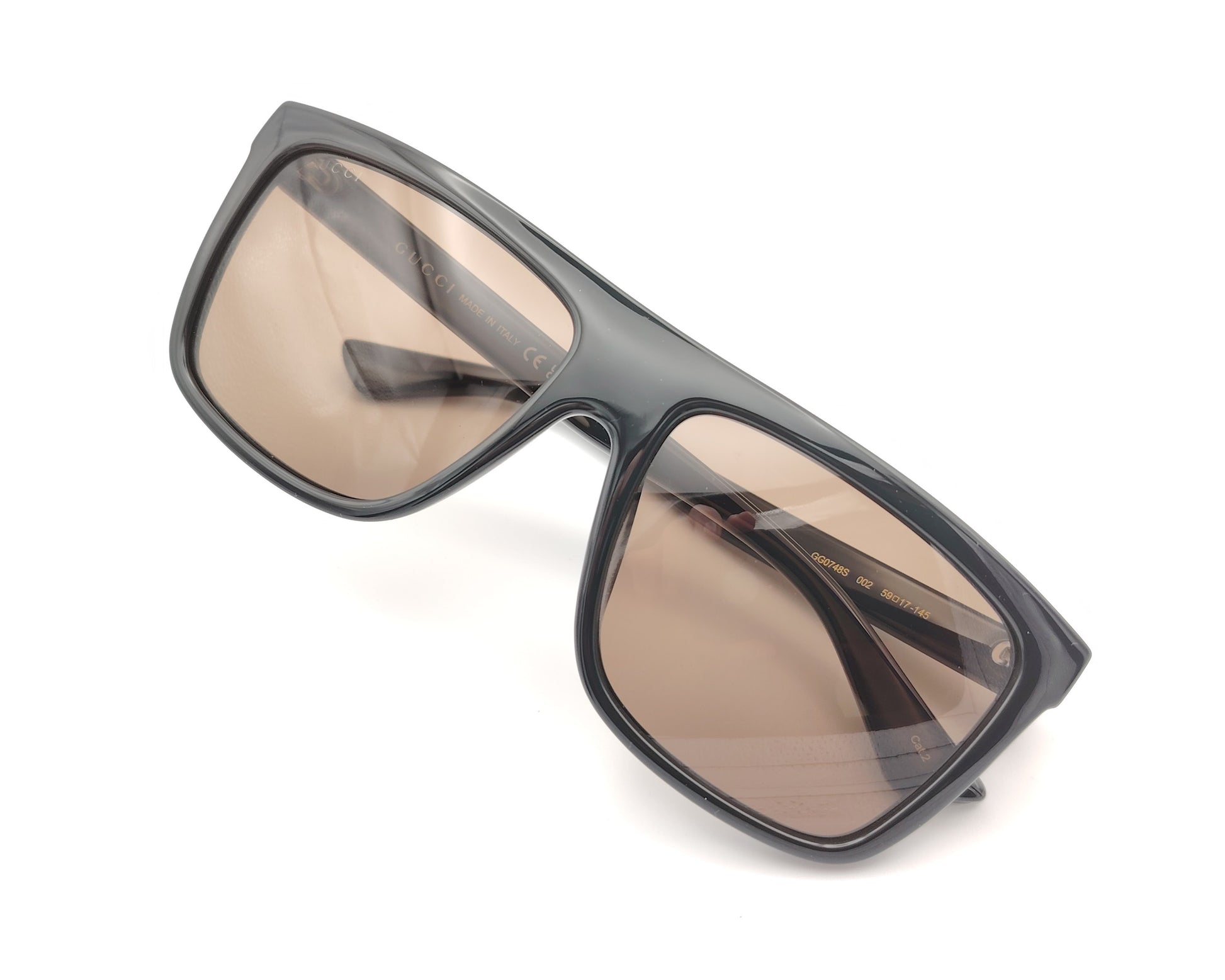 gafas de sol gucci con montura negra ancha y lentes marrones de forma cuadrada