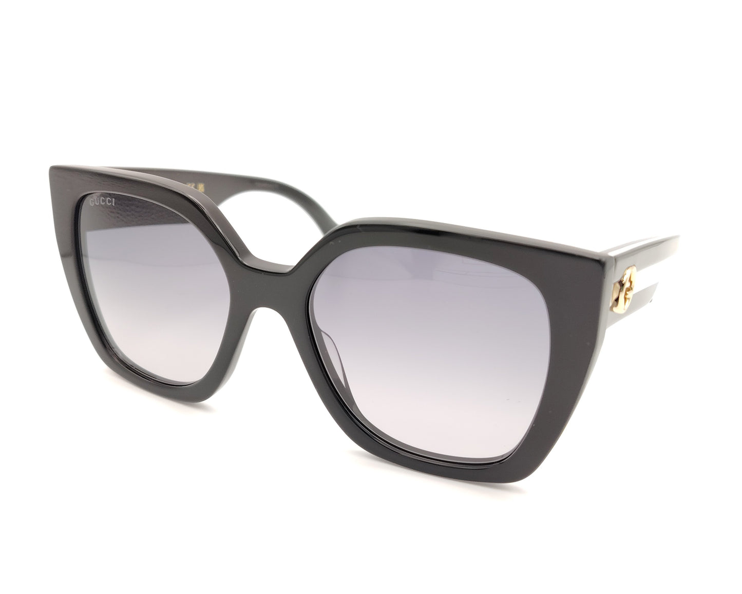 gafas de sol gucci negras oversize y detalle de logo dorado en las patillas bicolor