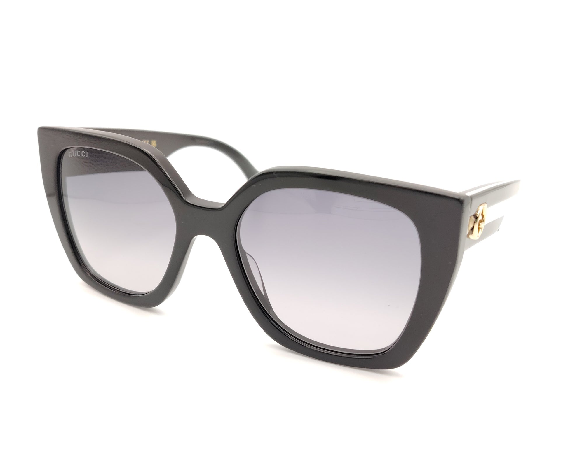 gafas de sol gucci negras oversize y detalle de logo dorado en las patillas bicolor