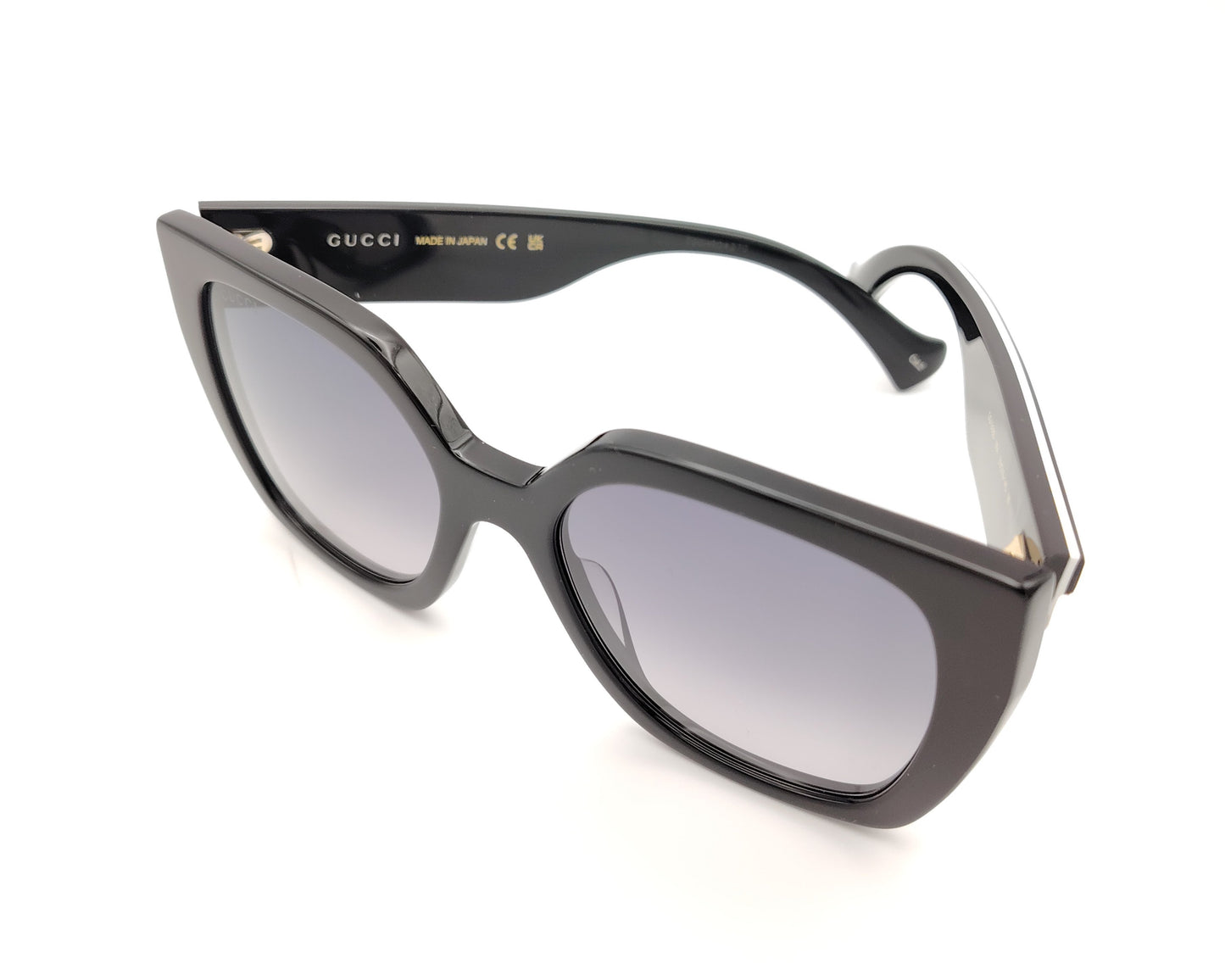 gafas de sol gucci negras oversize y detalle de logo dorado en las patillas bicolor