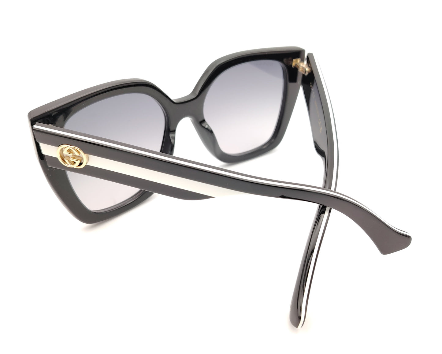 gafas de sol gucci negras oversize y detalle de logo dorado en las patillas bicolor