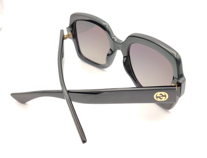 gafas de sol gucci negras con montura cuadrada oversize y logo dorado en la varilla