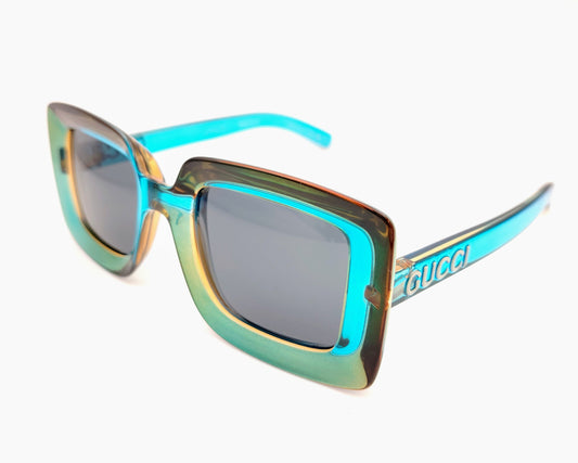 gucci gg1718s 005 gafas de sol en formato rectangular de pasta en color tornasolado azul turquesa y dorad, cristales en color gris