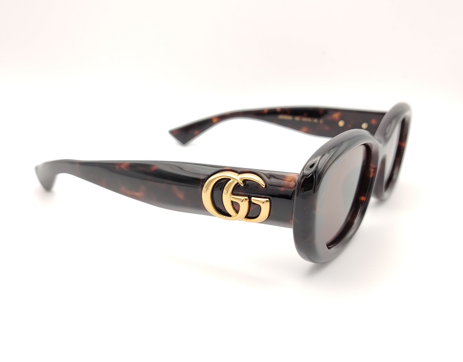 gafas de sol gucci ovaladas con montura carey y logo dorado en la varilla