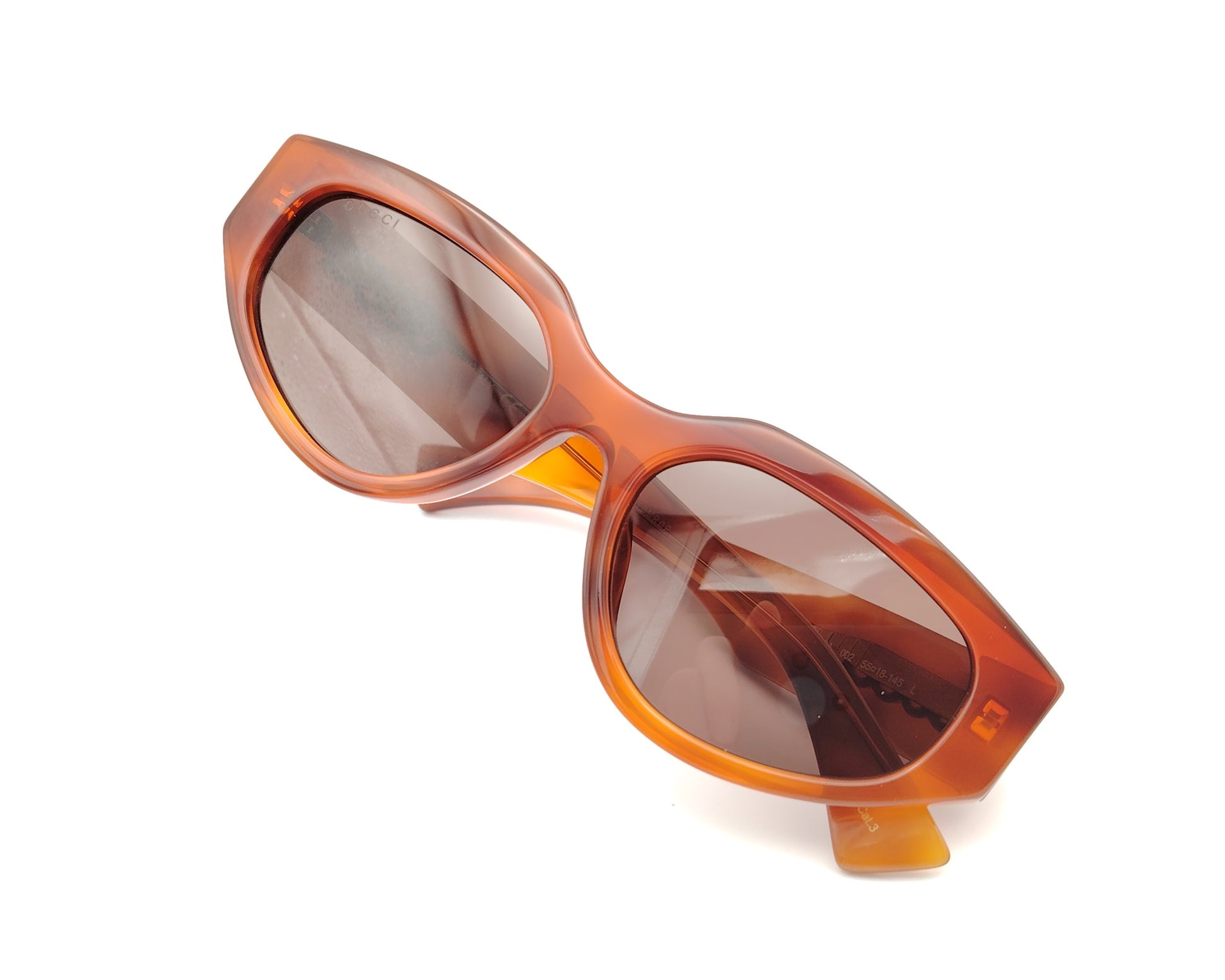 gafas de sol ojo de gato en acetato ámbar con lentes marrones y patillas con logo dorado