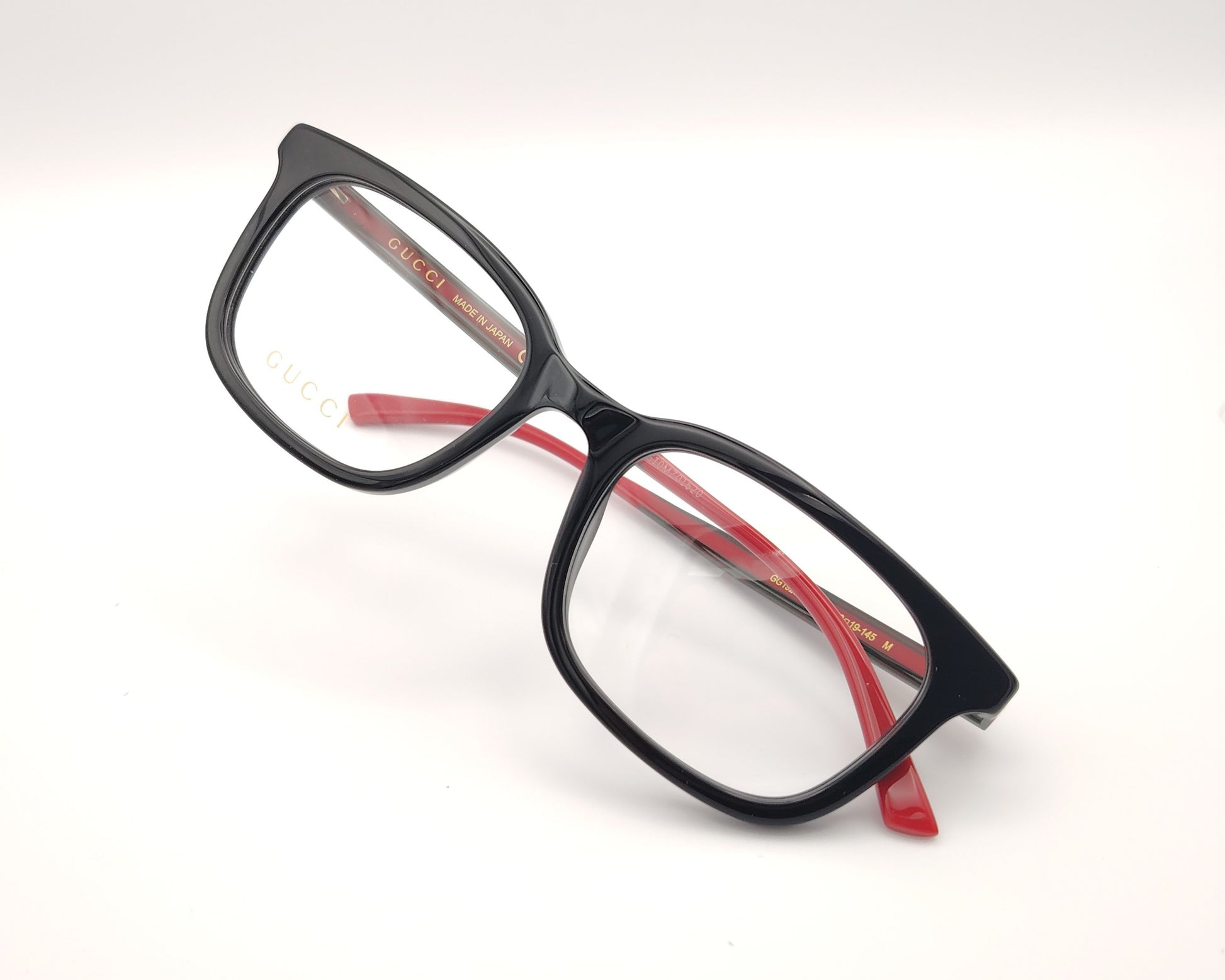 gafas gucci de pasta negra y varillas en rojo y verde con logo dorado