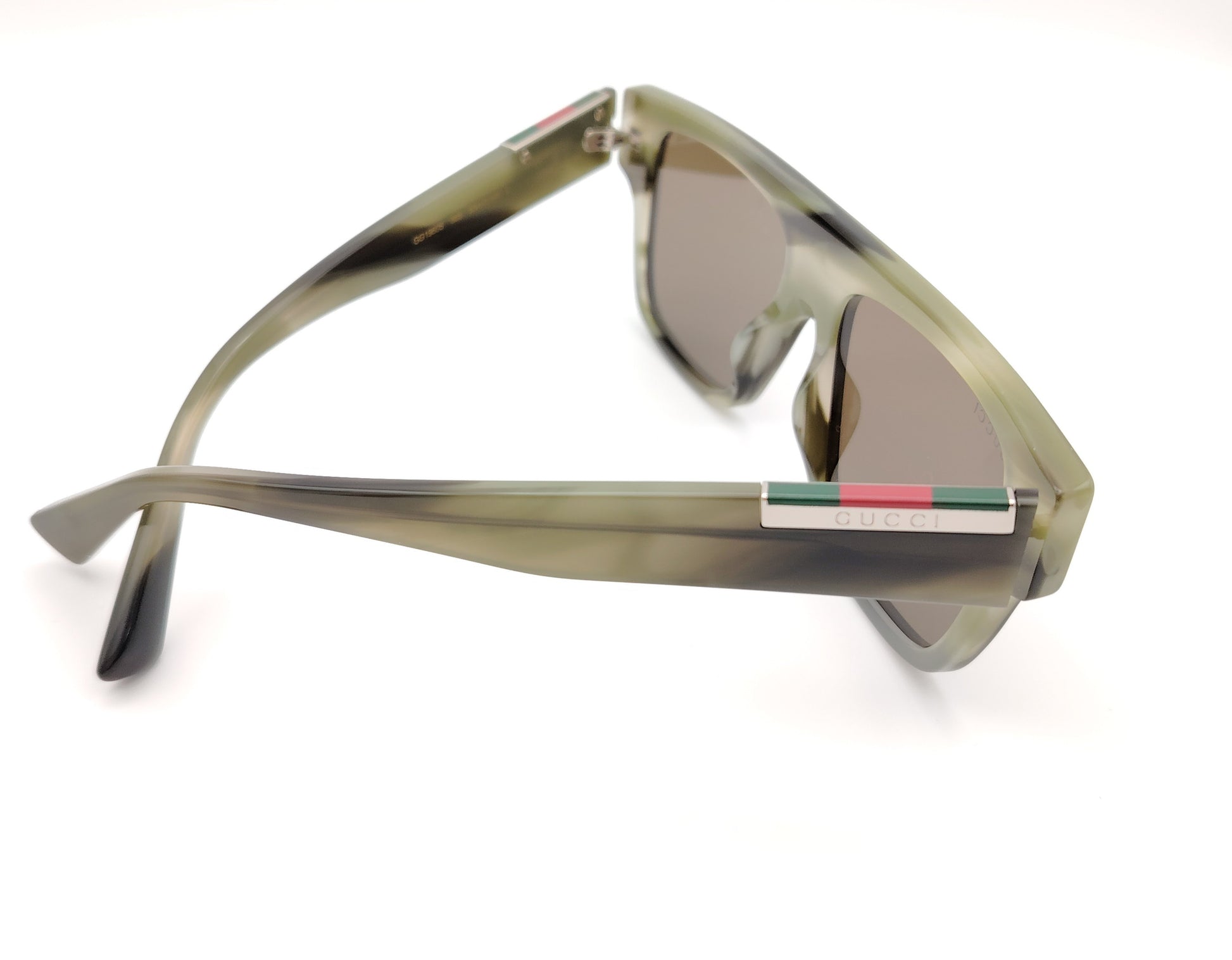 gafas de sol gucci con montura cuadrada verde translúcida y lentes marrones
