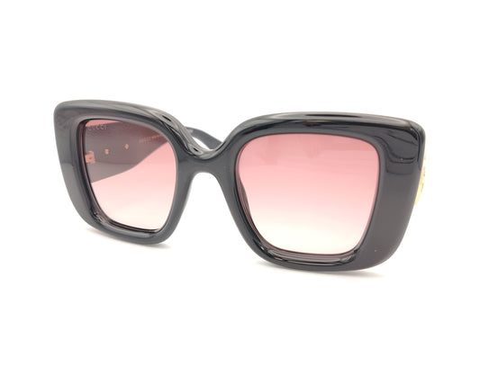 gafas de sol gucci negras con lentes rosa degradado y logo gg dorado en las varillas