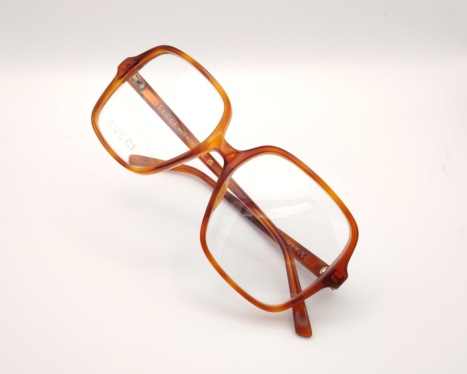 gafas gucci cuadradas de acetato caramelo con logo dorado en las varillas