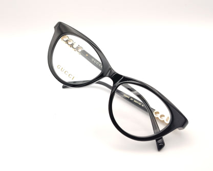 gafas gucci negras redondeadas con logo dorado en varilla